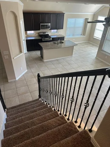 a kitchen with a refrigerator and a stove top oven