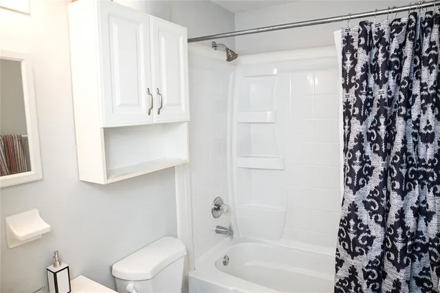 a bathroom with a shower curtain and a toilet