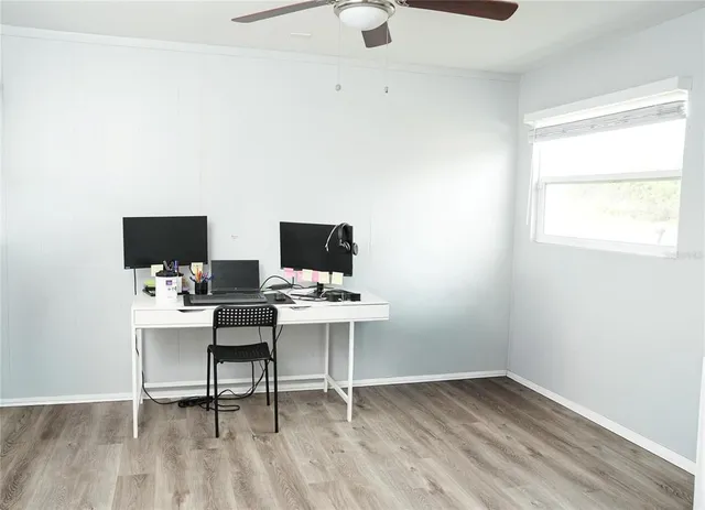 a view of a workspace with furniture and wooden floor