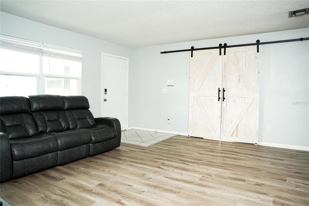 821 Barber Street Sebastian, FL 32958 - Photo 4 of 29 a living room with a couch window and a wooden floor