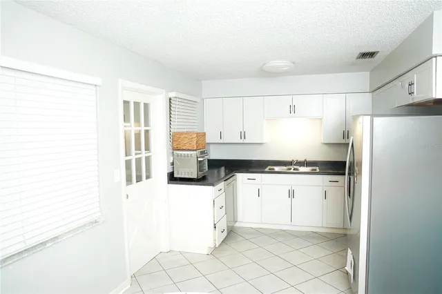 a kitchen with granite countertop white cabinets and white appliances