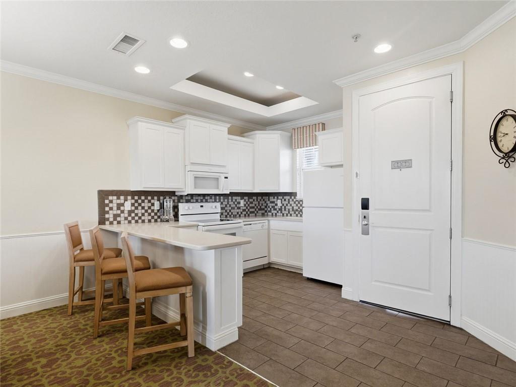 150 Apple Seed Court, Unit 131 Clarkesville, GA 30523 - Photo 3 of 40 a kitchen with white cabinets and chairs