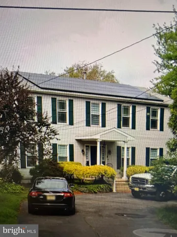 a car parked in front of a white house