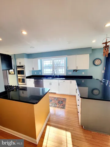 a kitchen with stainless steel appliances granite countertop a sink and a wooden cabinets