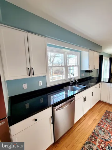 a kitchen with granite countertop a sink and a stove top oven