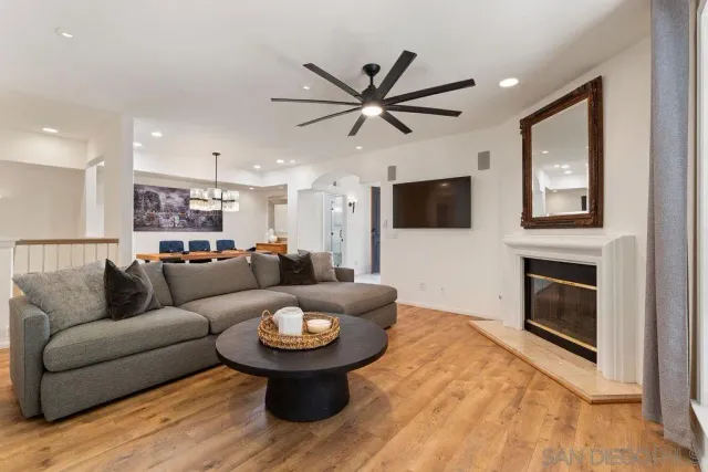 a dining room with wooden floor a chandelier a wooden table and chairs