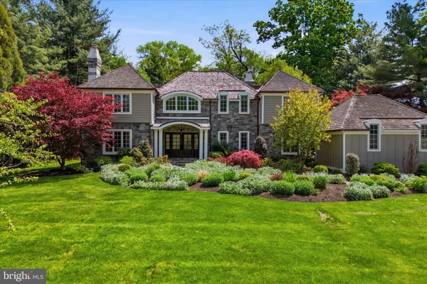 a front view of a house with a yard and potted plants