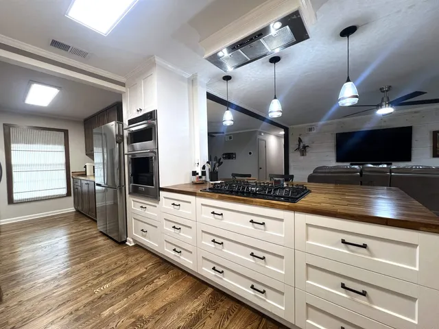 a kitchen with granite countertop a large counter top space and stainless steel appliances