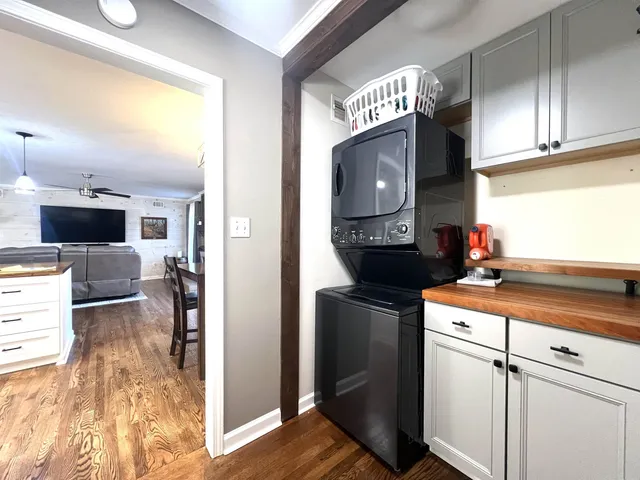 a kitchen with stainless steel appliances kitchen island granite countertop a stove top oven a sink dishwasher a dining table and chairs with wooden floor