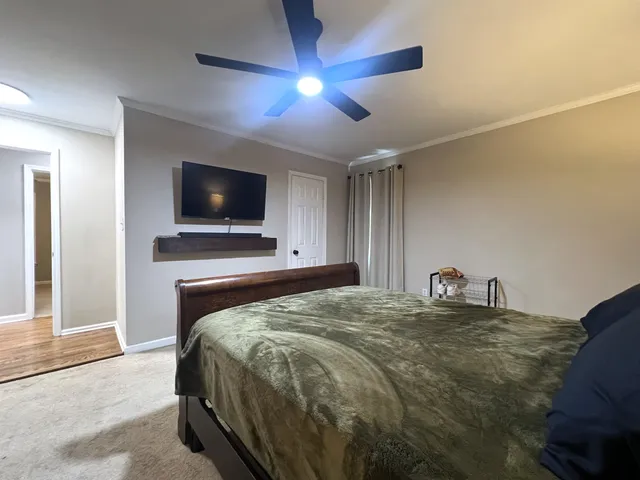 a spacious bedroom with a bed and a chandelier