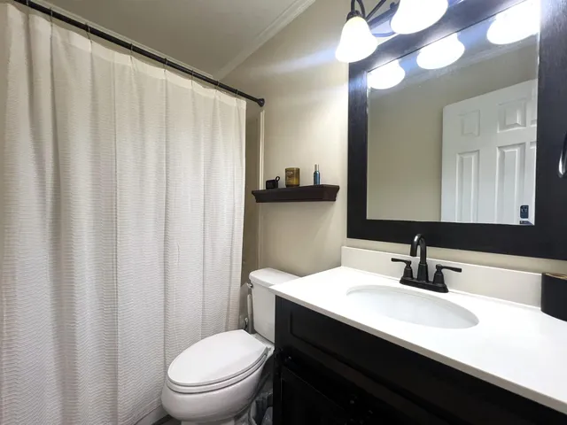 a view of an empty room with chandelier fan