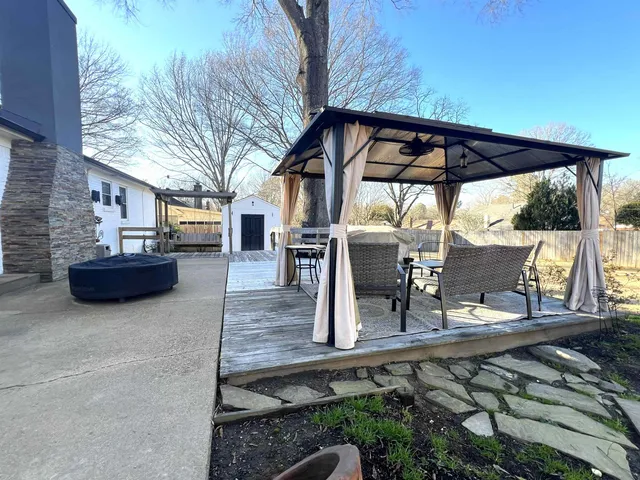 a view of house with backyard and sitting area