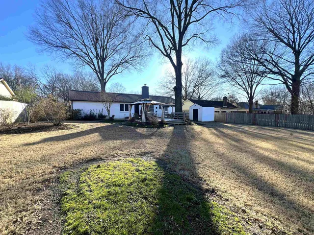 a view of a patio with table and chairs under an umbrella with wooden floor