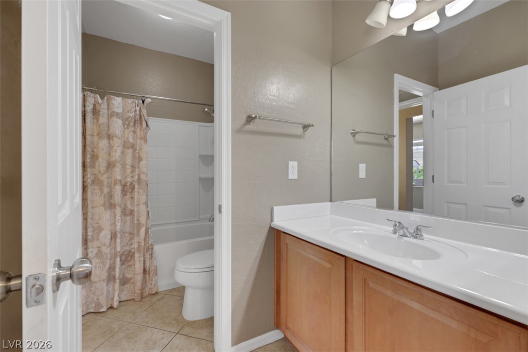 2501 Bechamel Place Henderson, NV 89044 - Photo 29 of 50 Tiled flooring and a modern vanity create a clean, functional bathroom space.