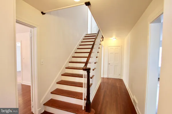 a view of a hallway with wooden floor and entryway