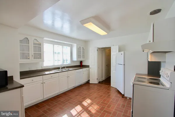 a room with a bed and a view of kitchen