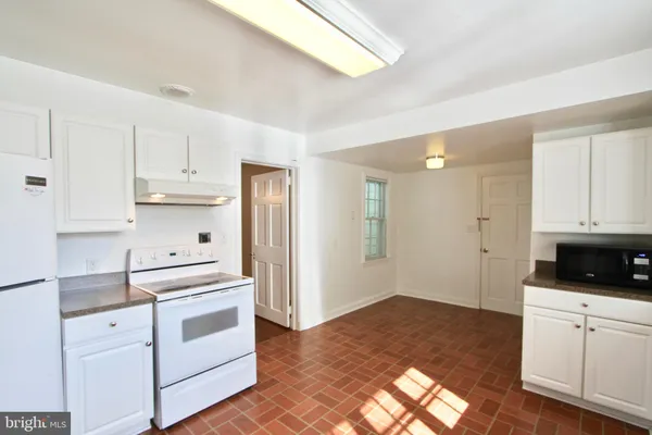 a kitchen with white cabinets and white appliances