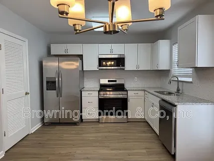 a kitchen with stainless steel appliances granite countertop a refrigerator and a stove top oven