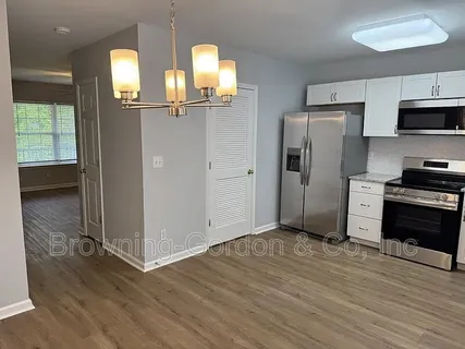 a view of a kitchen with wooden floor and electronic appliances