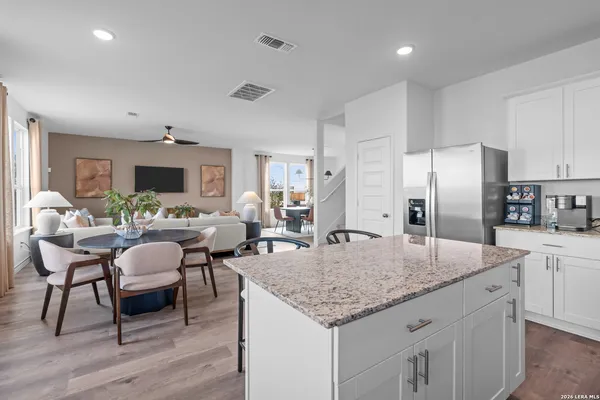 a large kitchen with kitchen island a large counter top space a sink appliances and cabinets