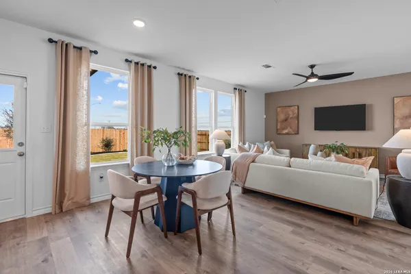 a living room with furniture a flat screen tv and a large window