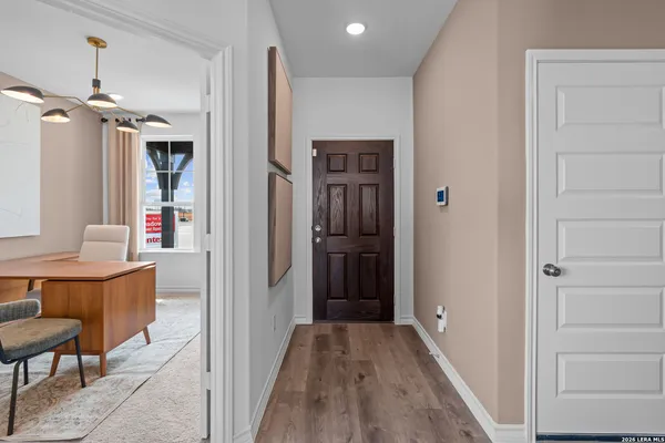 a view of a hallway with wooden floor and cabinet