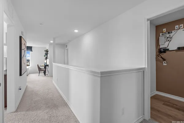 a view of a hallway with wooden floor and a living room
