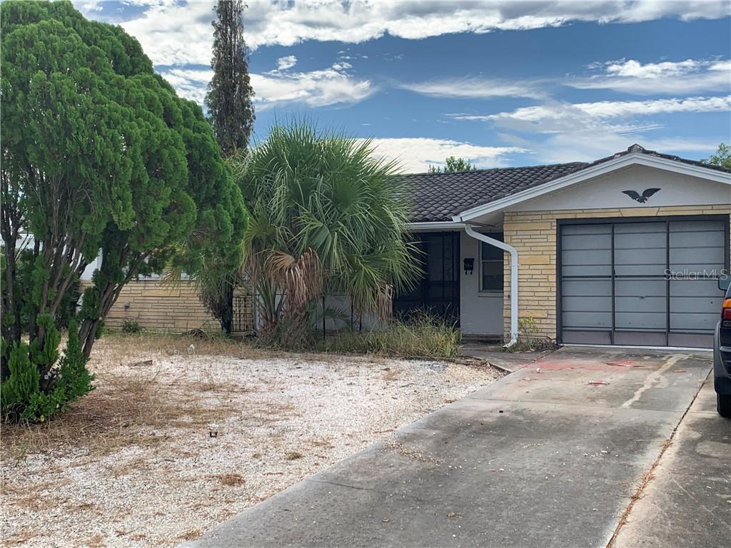 7830 Jasmine Boulevard Port Richey, FL 34668 - Photo 1 of 1 a front view of a house with a yard and garage