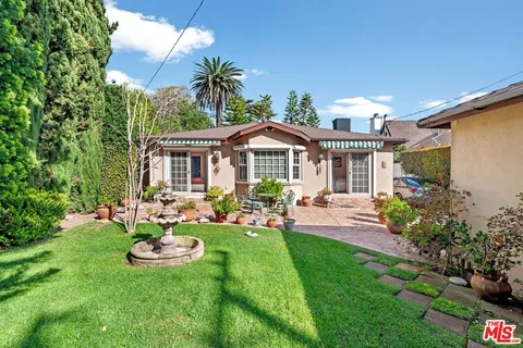 a view of a house with backyard and sitting area