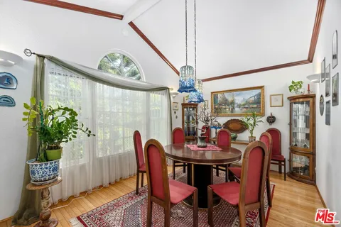 a dining room with furniture potted plants and wooden floor