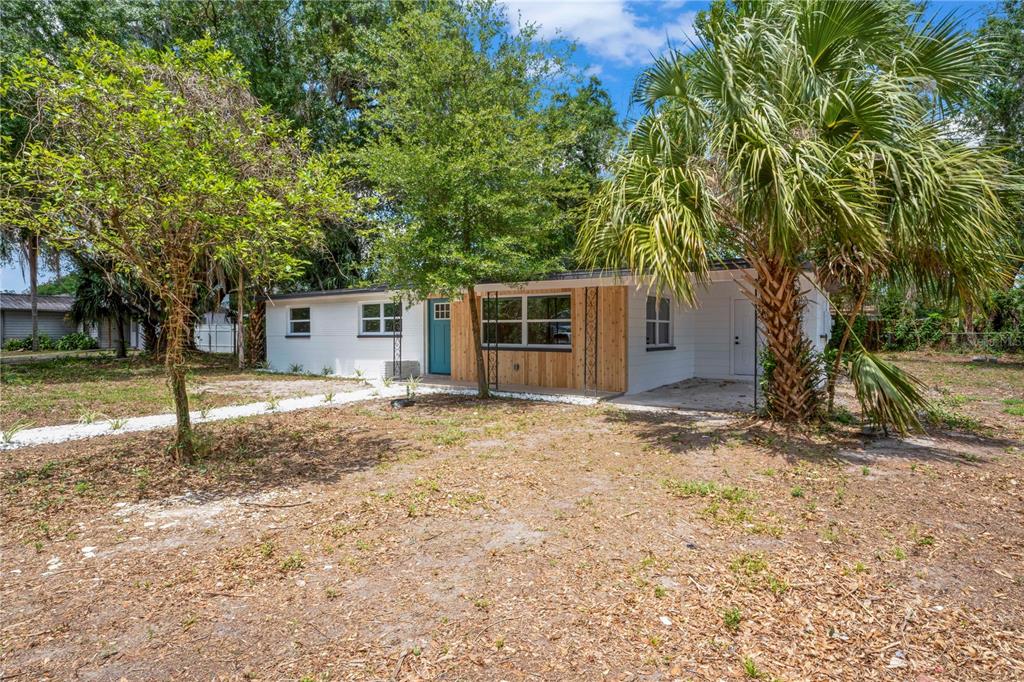1714 North Club Court Tampa, FL 33612 - Photo 1 of 18 a backyard of a house with lots of plants and large tree