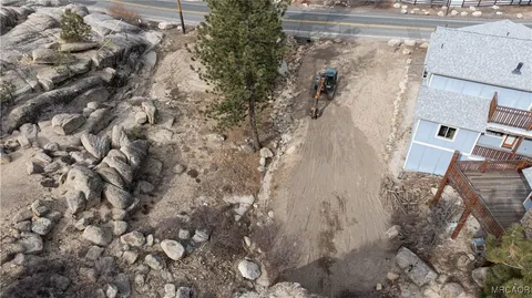 an aerial view of a house with a yard and parking spaces
