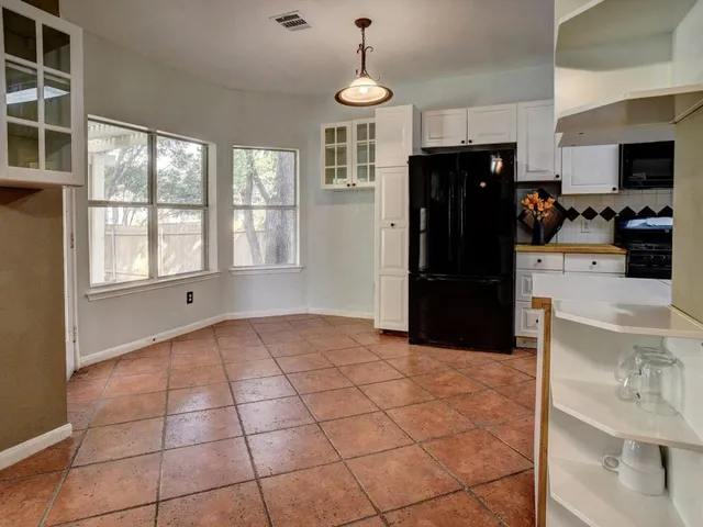 a kitchen with stainless steel appliances granite countertop a refrigerator and a stove top oven