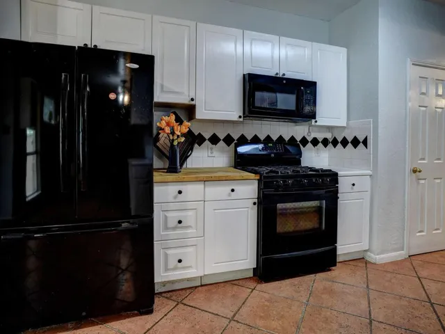 a kitchen with stainless steel appliances granite countertop a refrigerator and a stove top oven