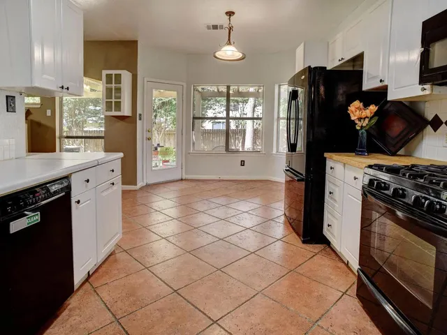 a kitchen with a sink a stove cabinets and counter space