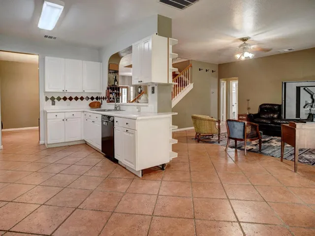 a view of an empty room with window and a kitchen