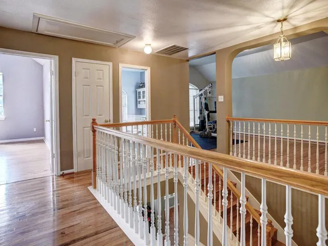 a view of a hardwood floor and staircase in a room