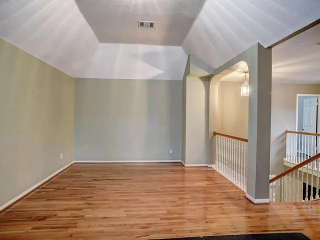 a spacious bedroom with a bed and a chandelier
