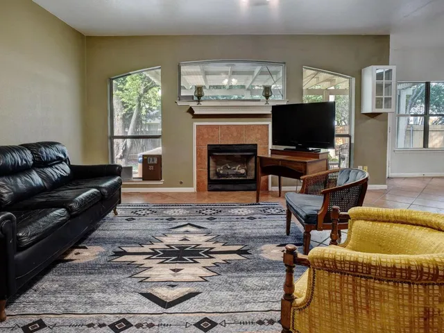 a living room with furniture a flat screen tv and a fireplace
