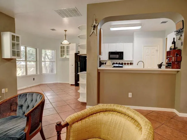 a kitchen with granite countertop a refrigerator and a stove top oven