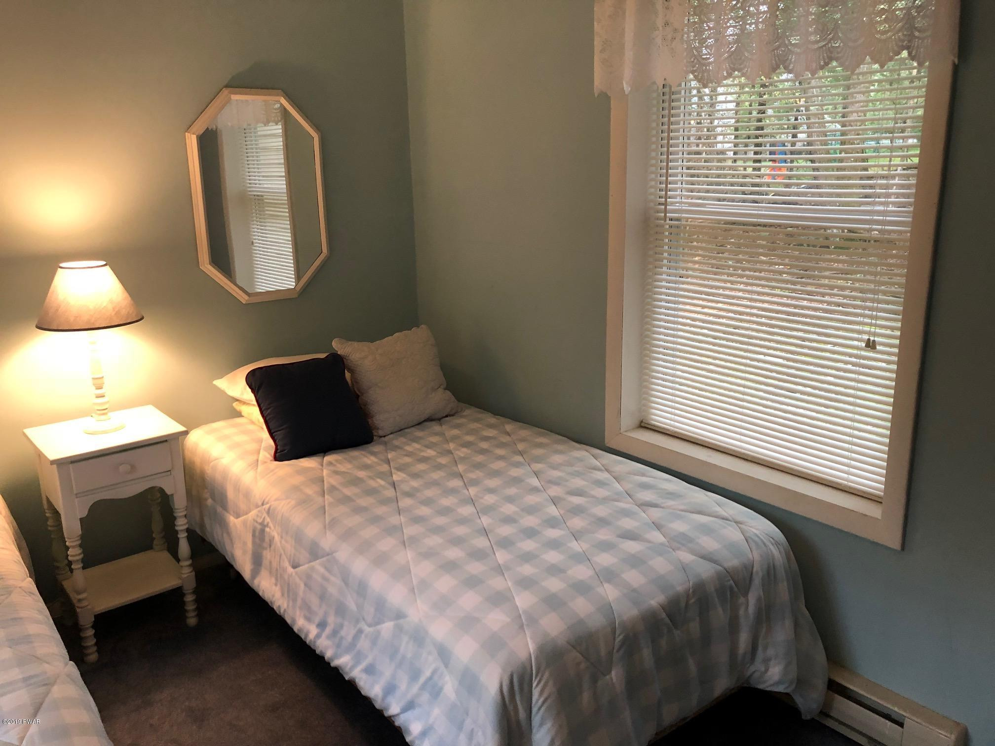 176 Heather Hill Road Dingmans Ferry, PA 18328 - Photo 16 of 32 a bedroom with a bed mirror and window