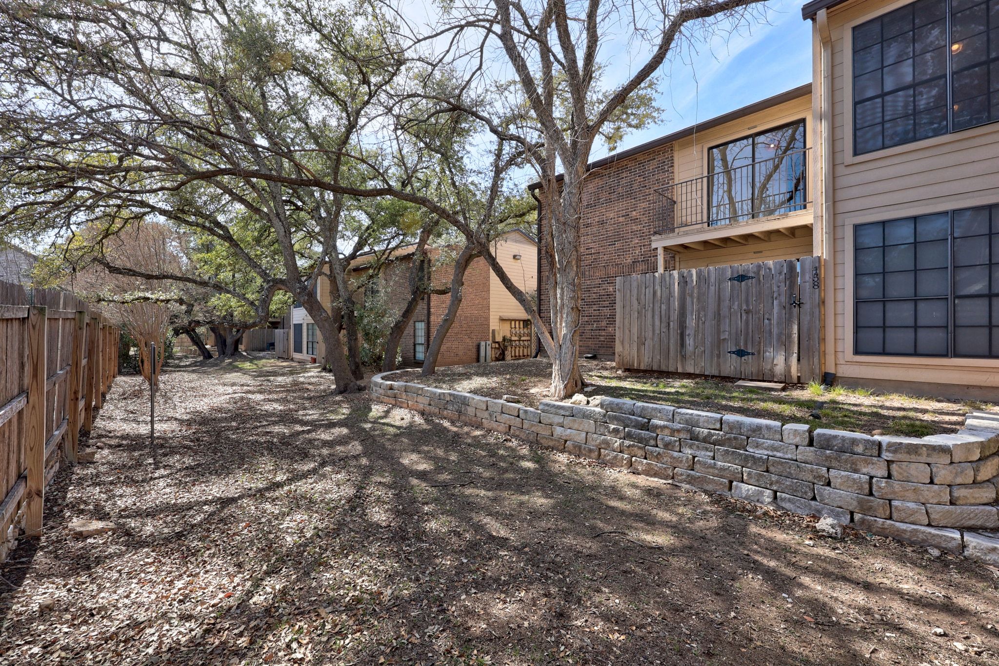 4159 Steck Avenue, Unit 258 Austin, TX 78759 - Photo 27 of 28 a view of a backyard with large trees and wooden fence