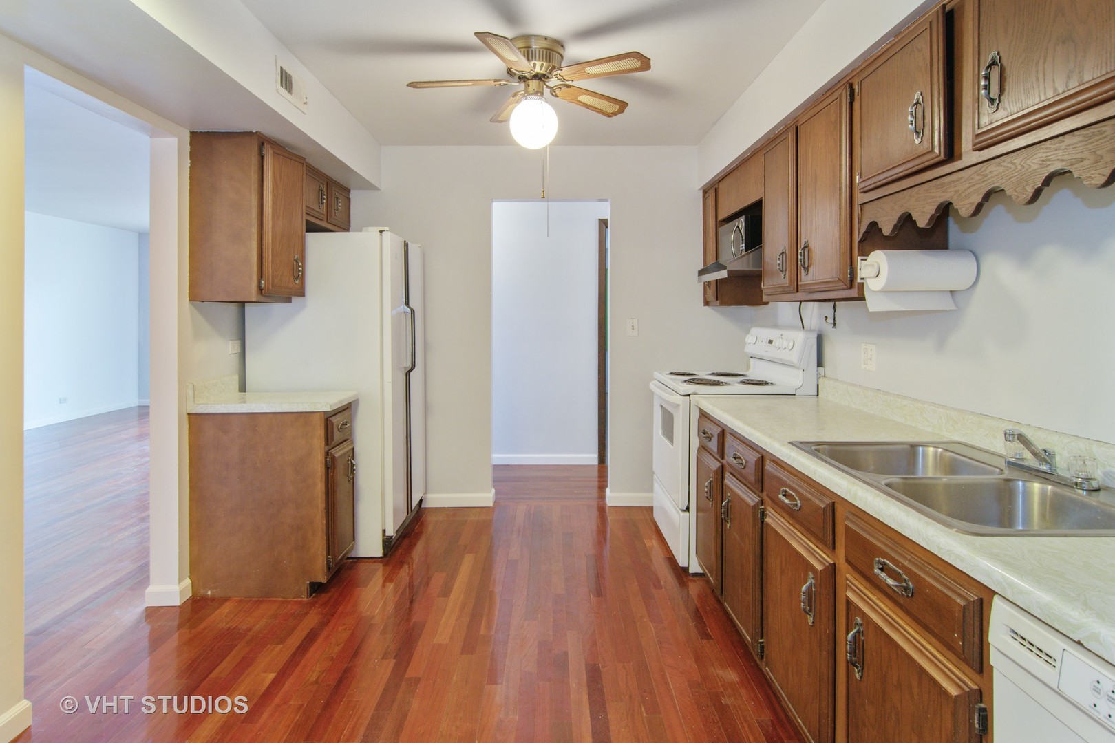 475 Shenstone Road, Unit 102 Riverside, IL 60546 - Photo 4 of 15 a kitchen with a sink a refrigerator a microwave oven cabinets and wooden floor