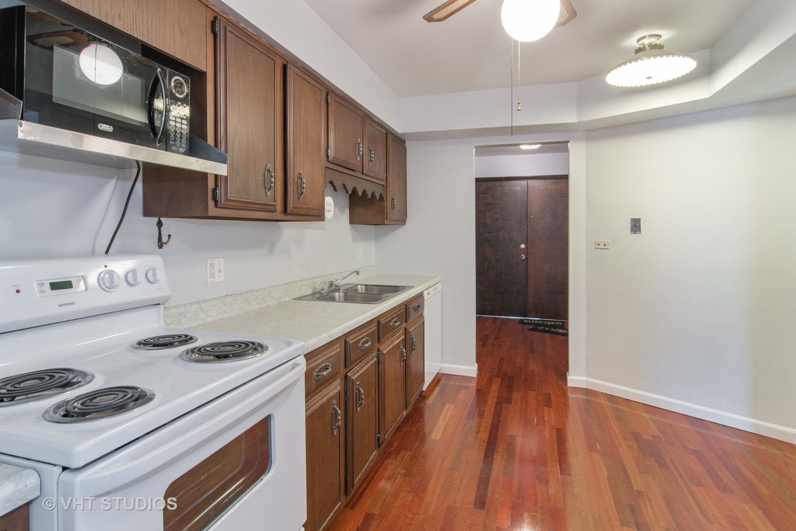 475 Shenstone Road, Unit 102 Riverside, IL 60546 - Photo 5 of 15 a kitchen with a stove a sink and wooden floor