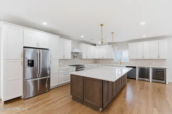 a large kitchen with stainless steel appliances granite countertop a sink a stove and a refrigerator