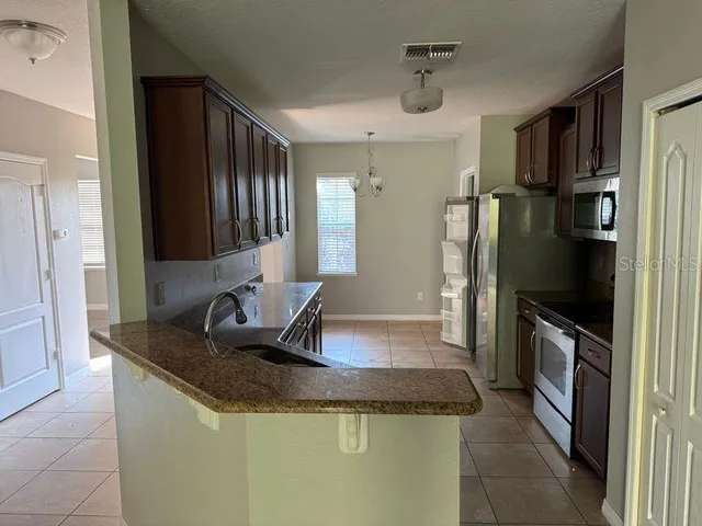 a kitchen with granite countertop a sink and stainless steel appliances