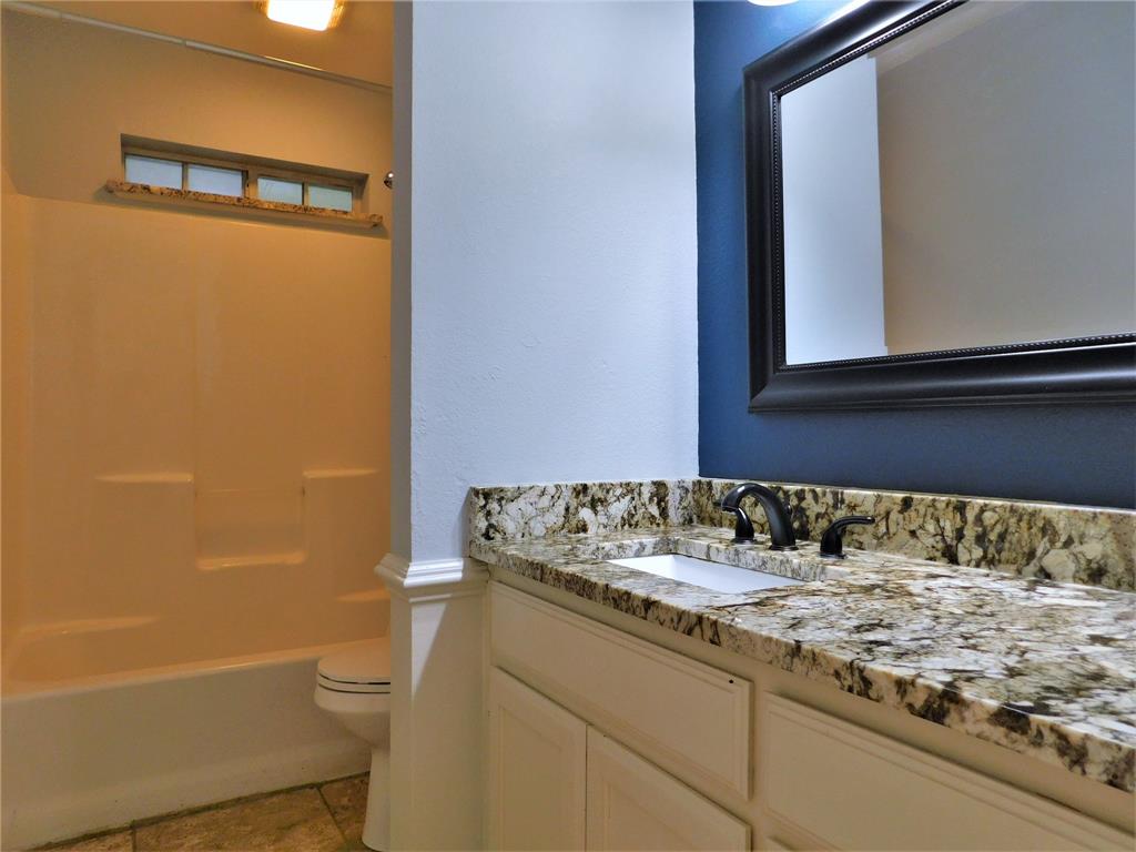 2001 Oak Tree Drive Denton, TX 76209 - Photo 24 of 34 a bathroom with a granite countertop sink toilet and shower