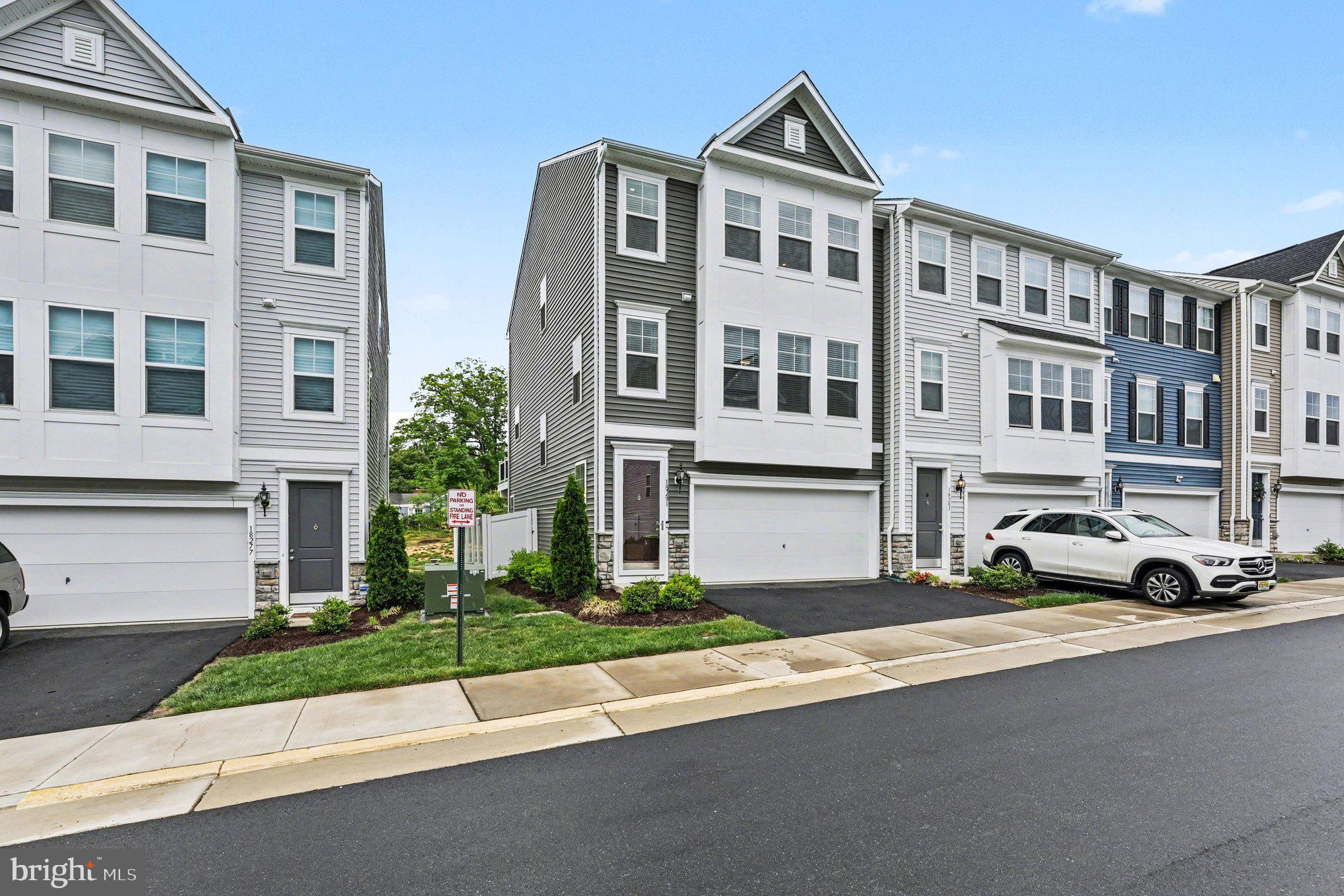 18281 Summit Pointe Drive Triangle, VA 22172 - Photo 2 of 30 a front view of a building with a yard and parking space