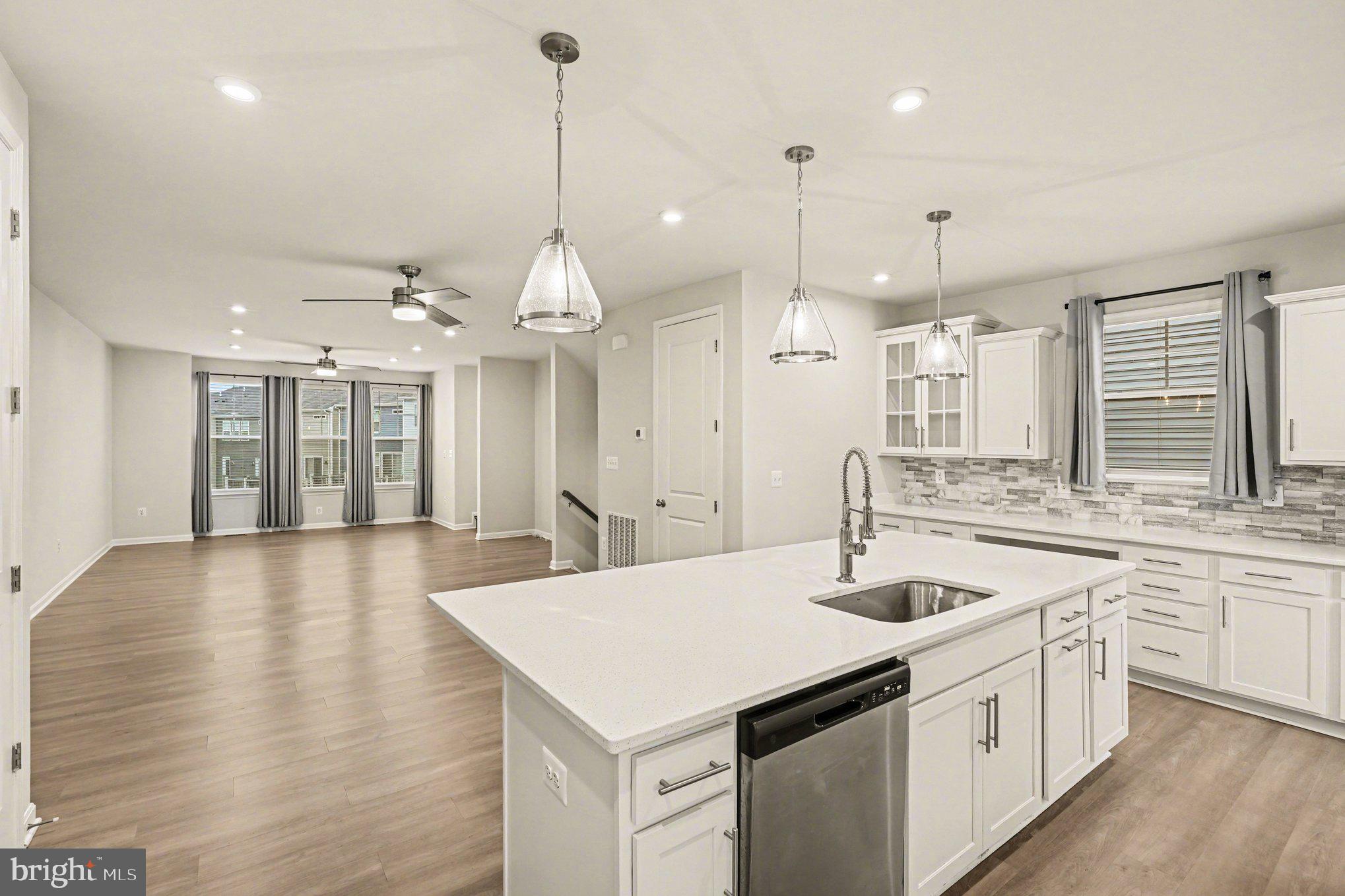 18281 Summit Pointe Drive Triangle, VA 22172 - Photo 6 of 30 an open kitchen with a sink and dishwasher with wooden floor