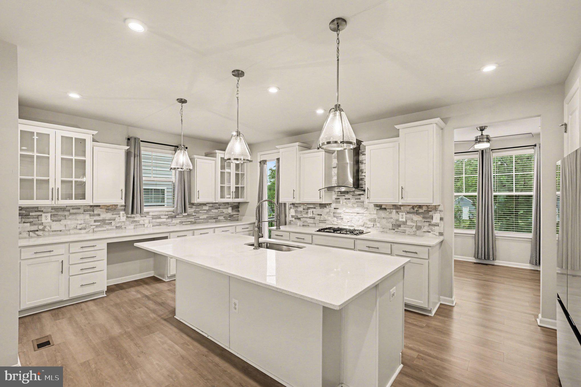 18281 Summit Pointe Drive Triangle, VA 22172 - Photo 8 of 30 a kitchen with kitchen island a stove a sink a center island and wooden floor